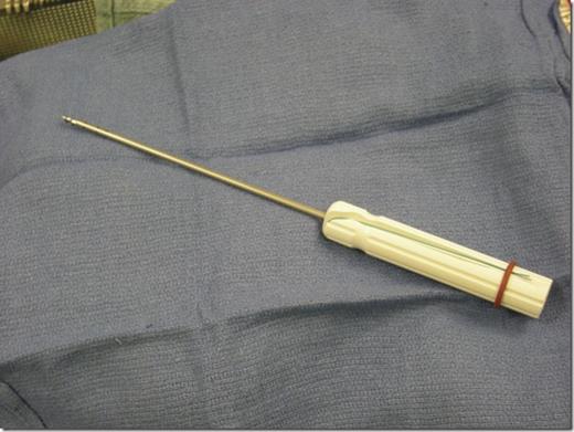 A Mitek Fastin bone anchor. The suture is attached to the bone anchor and is seen running in the handle.
